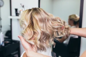 Freshly styled blonde hair with visible highlights in a salon.