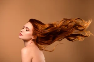 Woman with flowing, shiny red hair showing the benefits of keratin hair treatments.
