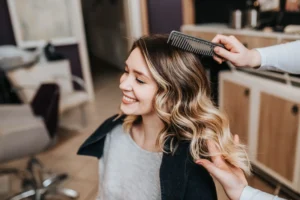 woman smiling with freshly highlighted hair styled in soft waves