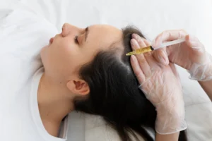 Provider performing scalp injection treatment on reclining patient