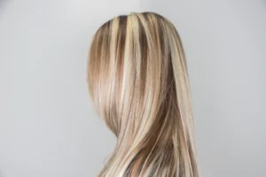 Back view of long straight hair with blonde balayage highlights against a light background.